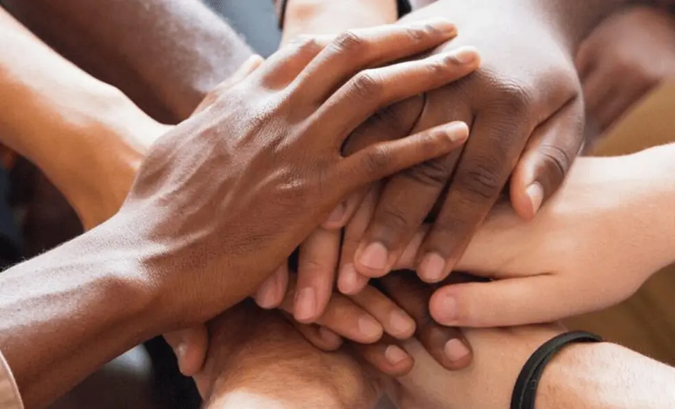 A group of people with their hands together.