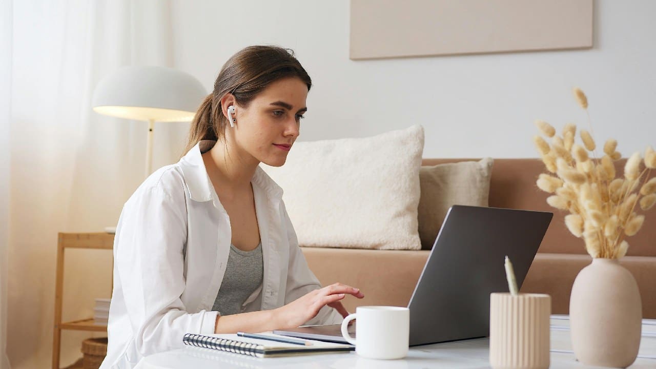 A woman sitting at a table with a laptop.